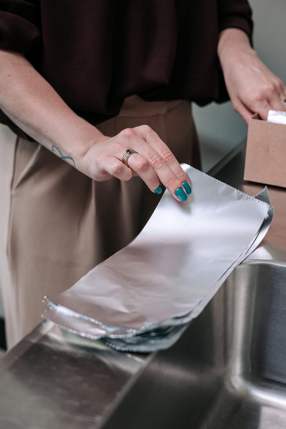 Nadine bereidt nauwkeurig de aluminiumfolies voor voor een kleurbehandeling.